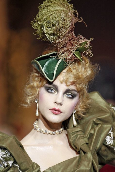 Modella con cappello a tricorno verde, acconciatura scolpita e abito in taffetà verde: il romanticismo settecentesco di John Galliano per Dior, autunno-inverno 2017.